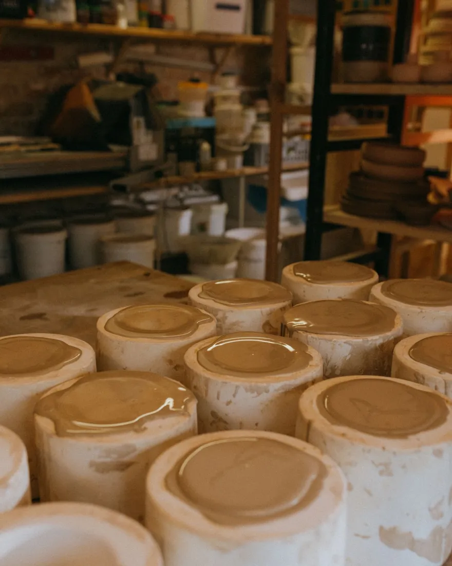 Moldes de escayola llenos de barbotina sobre la mesa de un taller de cerámica